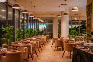 Chic and elegant restaurant interior featuring velvet chairs, wooden tables, and warm lighting.
